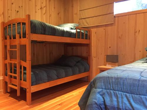 two bunk beds in a room with a bed at Cabañas Futrono in Futrono