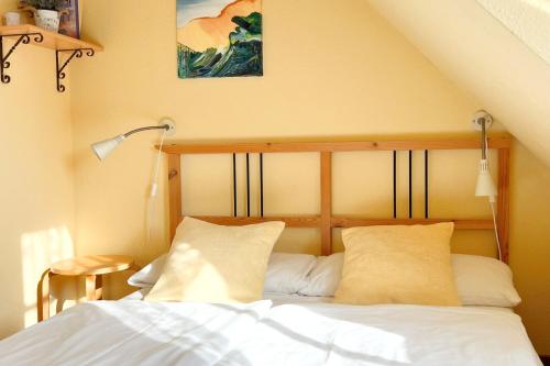 a bedroom with a bed with white sheets and pillows at Ferienwohung 3 Sandorn in Kölpinsee