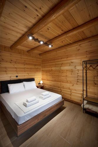 a bedroom with a large bed in a wooden room at Ο κισσός in Sklíthron