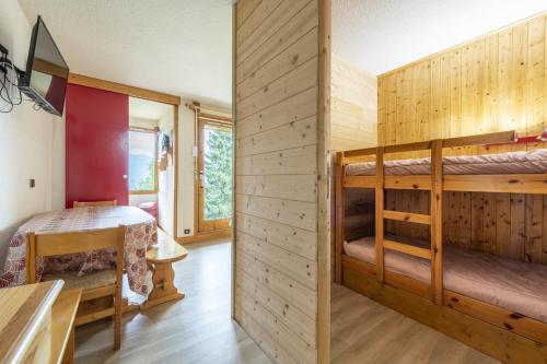 une chambre avec deux lits superposés et une table dans l'établissement Smartstay Flocon - La plagne - Les Coches, à Bellentre