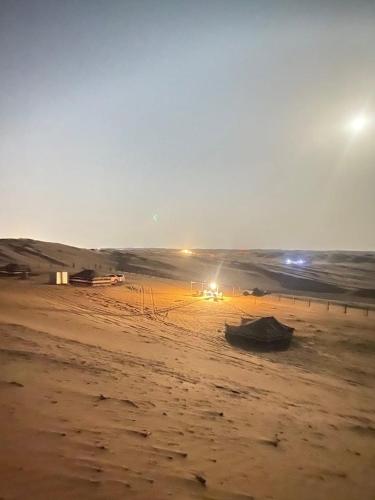a beach with a boat sitting on the sand at CAMP Bidiyah in Al Raka