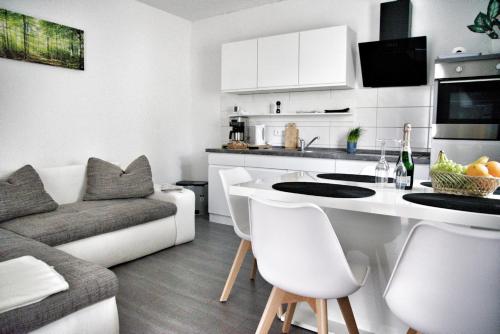 a kitchen and living room with a table and a couch at Nebengebäude in Mönkebude