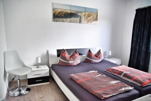 a bedroom with a blue bed with a chair and a desk at Nebengebäude in Mönkebude