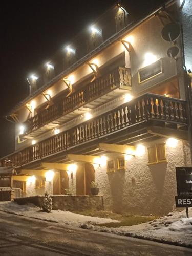 a building with a balcony at night at La Sapinière St Lary Soulan in Saint-Lary-Soulan