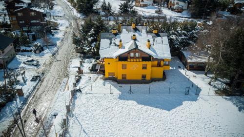 a yellow house in the snow with snow on it at Las Rocas By Base 41 in San Carlos de Bariloche
