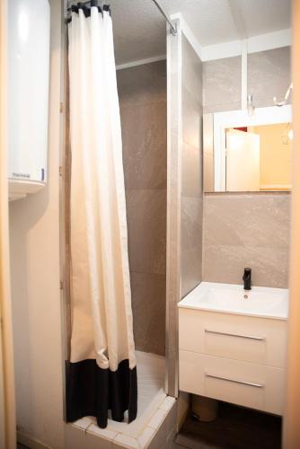 une salle de bain avec un rideau de douche et un lavabo dans l'établissement Poutran 2, studio 4 personnes au pied des pistes avec grande terrasse, à Oz