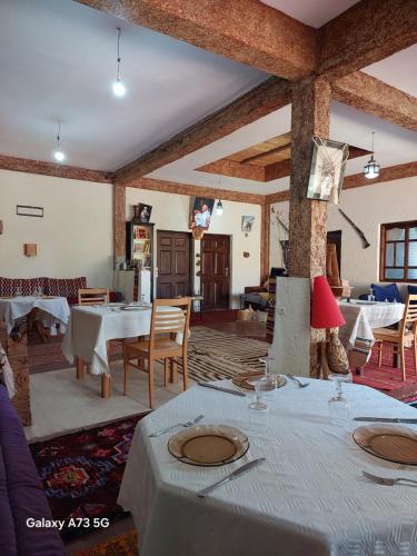 a living room with tables and chairs and a room with tablesktop at Riad dar idsalah in Ouirgane