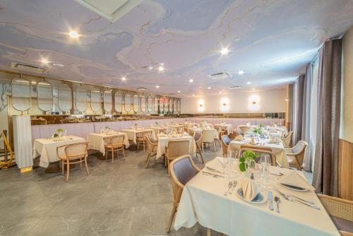 a restaurant with white tables and chairs and a map on the ceiling at Iris Hotel Boston in Brookline