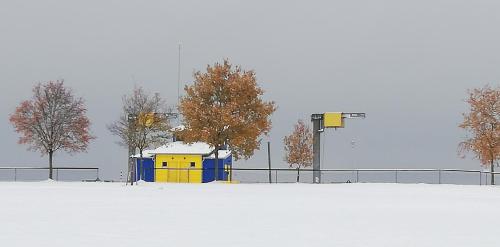 a snow covered field with trees and a building at Ferienhaus "Kleine Auszeit" in Pleinfeld