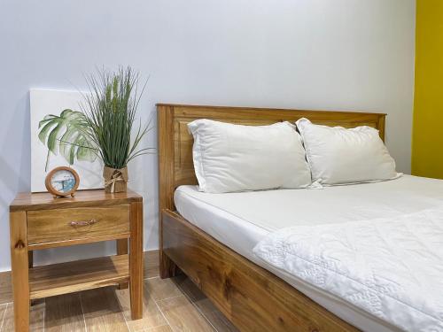 a bedroom with a bed and a table with a clock at Vania House in Ho Chi Minh City