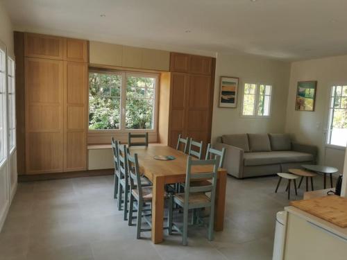 ラ・テスト・ド・ビュシュにあるMaison Alisan - Dune du Pilatのテーブルと椅子のあるキッチンとダイニングルーム