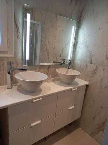 une salle de bain avec deux lavabos et un miroir dans l'établissement Maison Alisan - Dune du Pilat, à La Teste-de-Buch