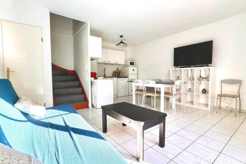 un salon avec un canapé et une table et une cuisine dans l'établissement Charmante maison 8min de Disney, à Magny-le-Hongre