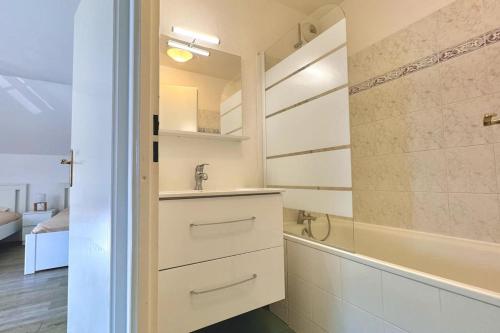 une salle de bain avec un lavabo et une baignoire dans l'établissement Charmante maison 8min de Disney, à Magny-le-Hongre