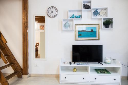 een woonkamer met een tv op een witte kast bij Cami s holidays home mare in Catania