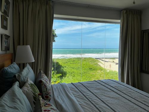 a bedroom with a bed and a view of the beach at Residencial Mañanero in Cabarete