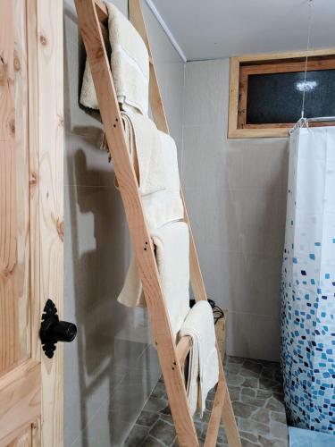 a ladder leaning against a wall with towels on it at Cabañas Futrono in Futrono