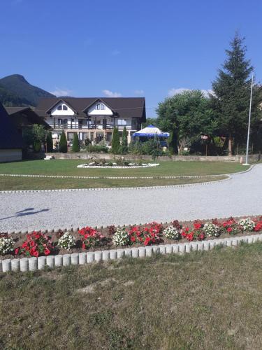 a house with a garden of flowers in a yard at Ge-Lux in Inceşti