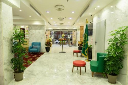 a lobby with chairs and plants in a building at فندق كروان جده in As Salamah