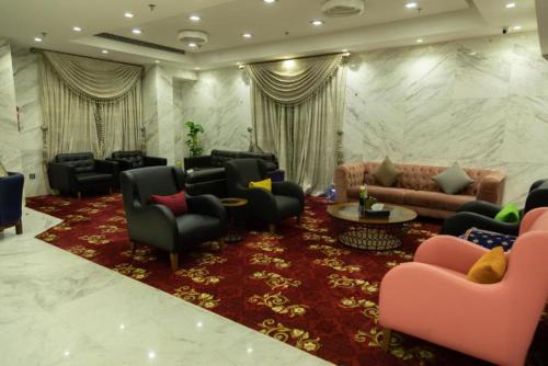 a living room with couches and chairs and a red rug at فندق كروان جده in As Salamah