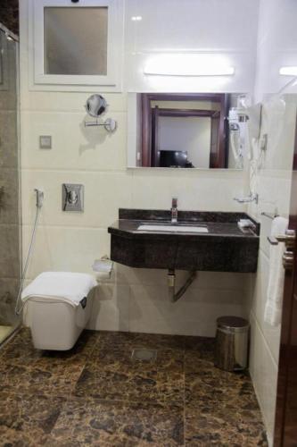 a bathroom with a sink and a toilet at فندق كروان جده in As Salamah