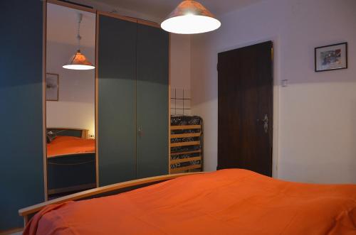 a bedroom with an orange bed and a mirror at Gästehaus Christophorus in Innerkrems