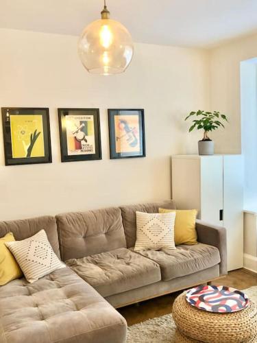 a living room with a brown couch in a room at Flat1Hove- renovated, 2BR, patio, beach, free onsite parking in Hove
