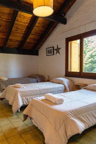 a room with three beds in a room with a ceiling at Las Rocas By Base 41 in San Carlos de Bariloche