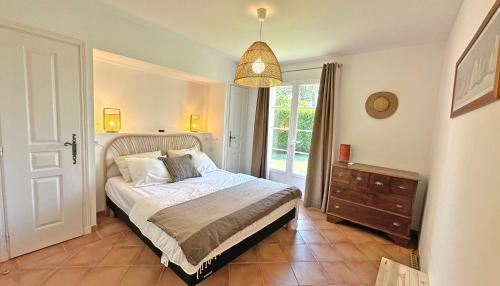 une chambre avec un lit, une commode et une fenêtre dans l'établissement Restanques - Beauchêne, à Sainte-Maxime