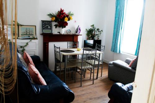 a living room with a couch and a table at Spacious 4-Bed House - Sleeps 5 Garden & Parking in London