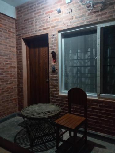 a room with a table and a chair and a window at Mount Fuji Homestay in Deorāli