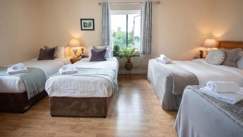 a room with three beds and a window at Waterfront View Apartment in Carrick on Shannon