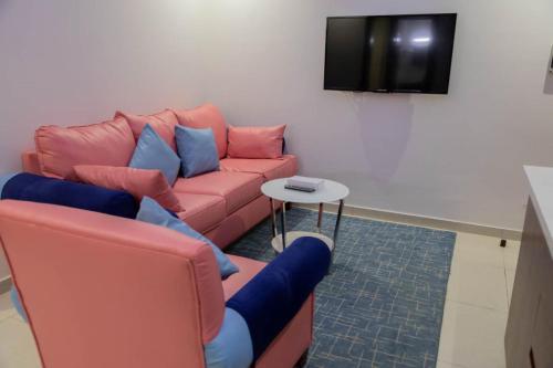 a living room with a couch and a tv at فندق كروان جده in As Salamah
