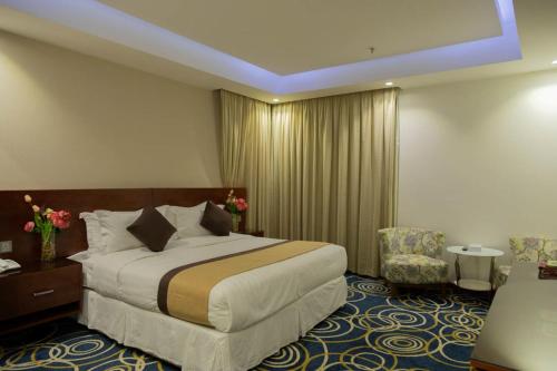 a hotel room with a bed and a chair at فندق كروان جده in As Salamah
