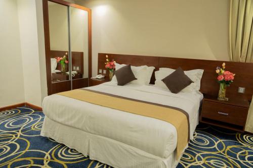 a bedroom with a large bed and a mirror at فندق كروان جده in As Salamah