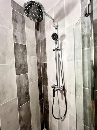 une douche avec pommeau de douche dans une salle de bain dans l'établissement Les chambres de la bastide - 105, à Carcassone