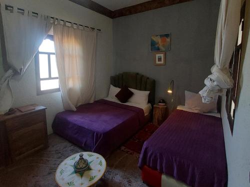 a small room with two beds and a window at Riad dar idsalah in Ouirgane