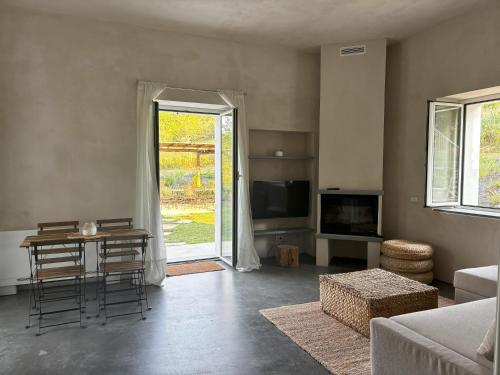 a living room with a couch and a table and a tv at La Torre Granaia in Serravalle Scrivia