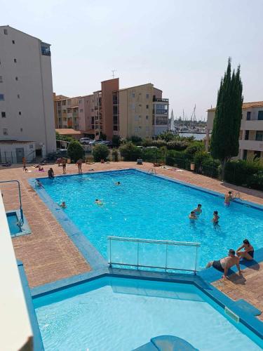 une grande piscine avec des gens dans l'eau dans l'établissement Studio cabine climatisé sur l'île des pêcheurs, au Cap d'Agde