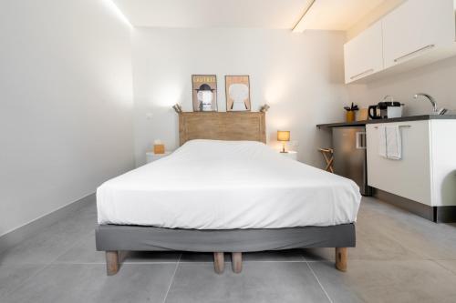 a large bed in a room with a kitchen at Apparts de l'Oncle Louis in Versailles