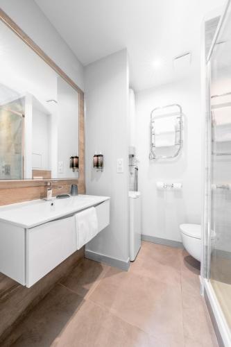 a white bathroom with a sink and a toilet at Apparts de l'Oncle Louis in Versailles