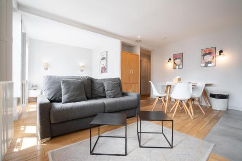 a living room with a couch and a table at Apparts de l'Oncle Louis in Versailles