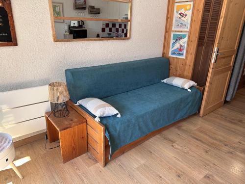 un canapé bleu dans une pièce avec une table dans l'établissement Les Cîmes des Carroz, aux Carroz d'Arâches