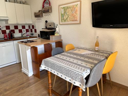 une cuisine avec une table recouverte d'une nappe dans l'établissement Les Cîmes des Carroz, aux Carroz d'Arâches