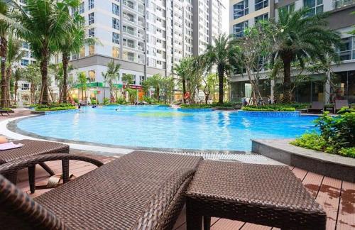 - une grande piscine dans un bâtiment avec des tables et des chaises dans l'établissement Hana homestay- 1 Phòng ngủ trong căn hộ chủ nhà đang ở tại Park 4-Vinhome Central Park Tân cảng Bình Thạnh HCM- sát landmark 81, à Hô-Chi-Minh-Ville