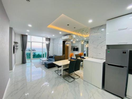 a kitchen and a living room with a table at Paradise Condotel Mũi Né - Căn hộ nghỉ dưỡng Ocean Vista in Ấp Ngọc Hải