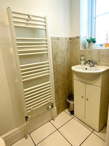 a small bathroom with a sink and a shower at 3-bed cottage in Sway, New Forest (5 min walk from Sway Train Station) in Sway