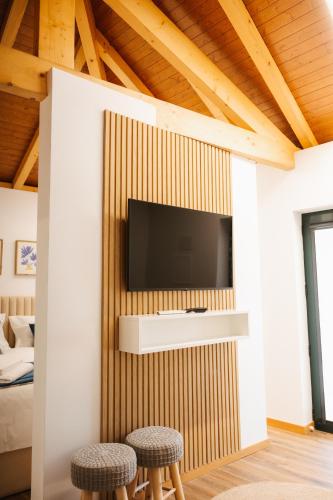 a living room with a tv and two stools at Alvarenga Apartments in Alvarenga