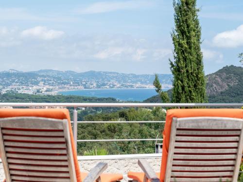 two chairs sitting on a balcony with a view of a lake at Holiday Home Domaine de Maure Vieil by Interhome in La Napoule-Plage