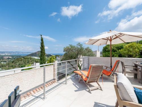 a patio with two chairs and an umbrella at Holiday Home Domaine de Maure Vieil by Interhome in La Napoule-Plage
